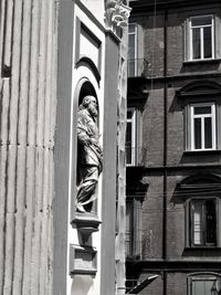 Low angle view of man standing by window of building