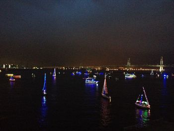 Illuminated boats in sea at night