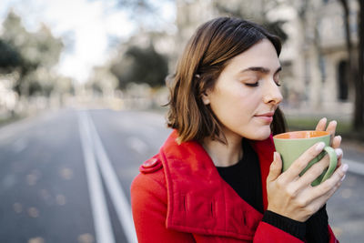 Portrait of young woman drinking coffee