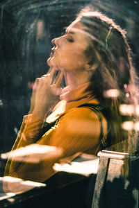 Side view of young woman smoking cigarette