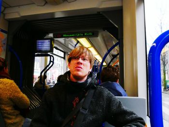 Portrait of young woman sitting in train