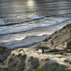 People standing on rocks at sea shore