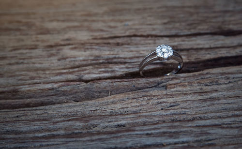 Close-up of wedding ring on wooden table