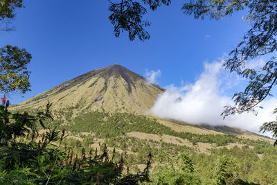 Scenic view of volcanic mountain against blue sky