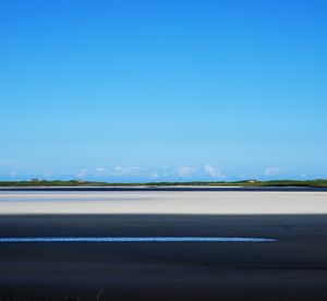 Road against clear blue sky