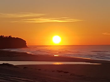 Scenic view of beach against sky during sunset