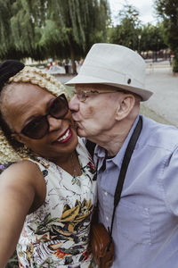 Senior man kissing woman in park