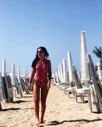 Woman standing on beach against clear sky