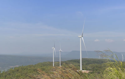 Wind turbines on land against sky