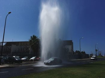 Fountain in city against sky