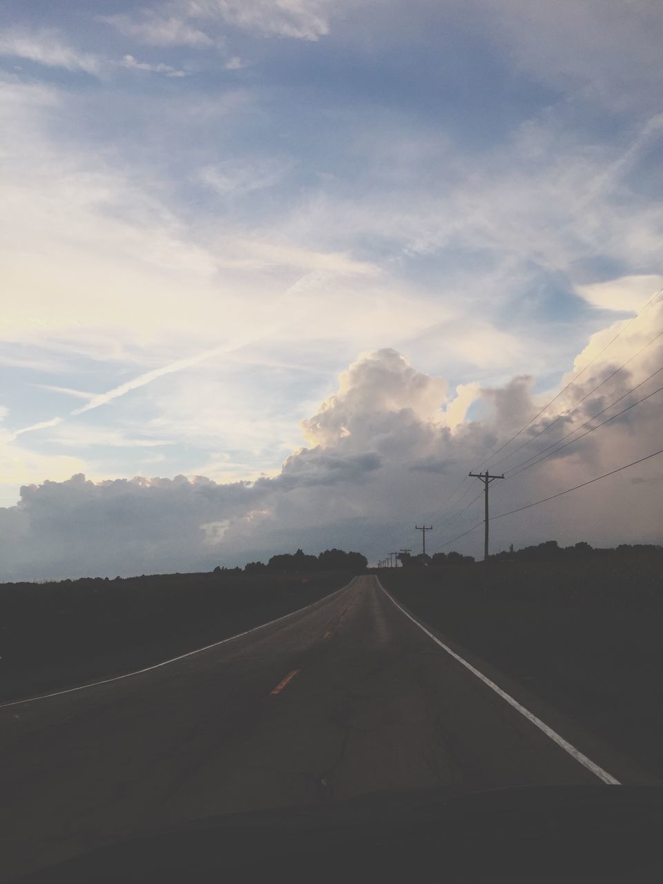 EMPTY ROAD WITH TREES IN BACKGROUND