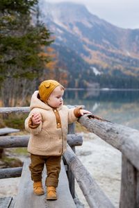 Portrait of young woman standing on railing