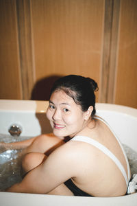 Portrait of shirtless young woman sitting at home