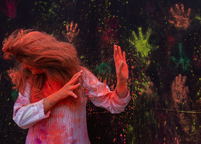 Woman with powdered paint showing stop gesturing during holi