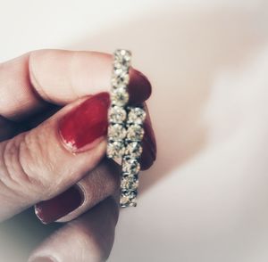 Close-up of woman holding hands over white background