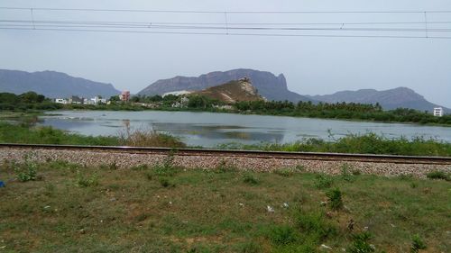 Scenic view of river by mountains against clear sky