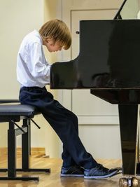 Side view of a boy playing the piano