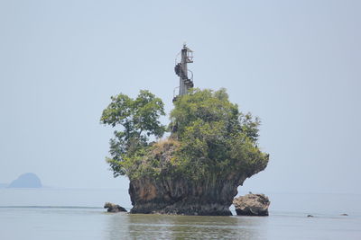 Scenic view of rock formation in sea against clear sky