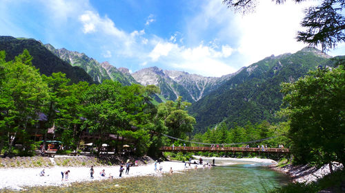 Scenic view of river and mountains against sky