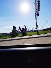 Man with umbrella on road against sky