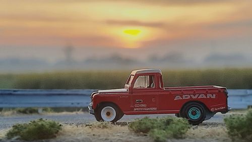 Vintage car on field against sky during sunset