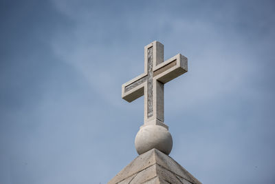 Low angle view of cross against sky