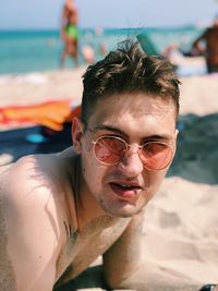 Portrait of man wearing sunglasses at beach
