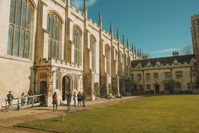 People in front of historical building against sky