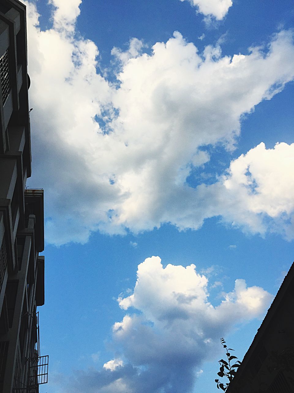 low angle view, sky, building exterior, architecture, built structure, cloud - sky, cloud, cloudy, high section, building, blue, city, outdoors, day, residential structure, residential building, no people, house, nature, roof