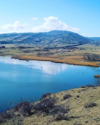 Scenic view of calm lake against cloudy sky