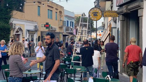 People on street against buildings in city