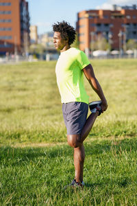 Man stretching leg on grass field