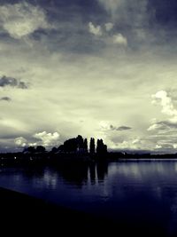 Silhouette of buildings against cloudy sky