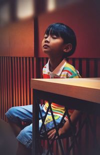 Portrait of a boy sitting on caffetaria chair.