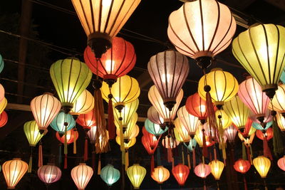 Low angle view of illuminated multi colored lanterns hanging from ceiling