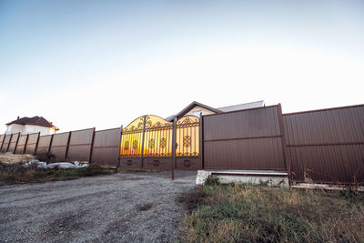 Brown fence with metal profile gate