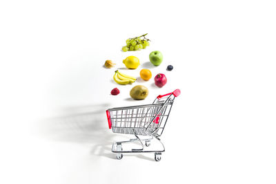 Various fruits in plate against white background