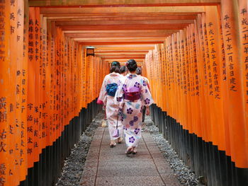 Rear view of women walking on footpath