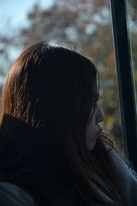 Close-up portrait of woman looking through window