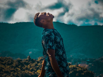 Side view of young man looking at sea