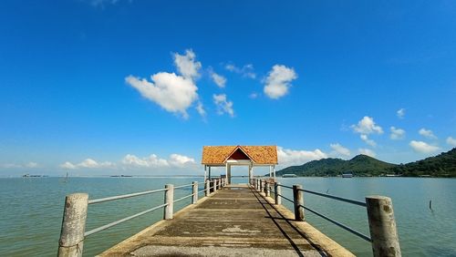 Pier over sea against blue sky