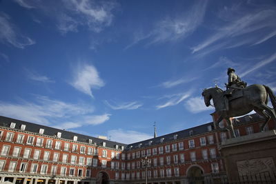 Low angle view of statue against building against sky