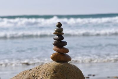 Close-up of stone stack on rock at beach