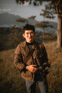 Young man photographing on field