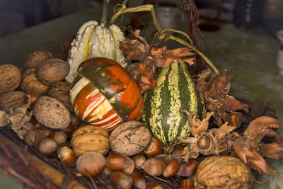 Beautiful walnuts, hazelnuts and decorative pumpkins placed in a decorative basket.