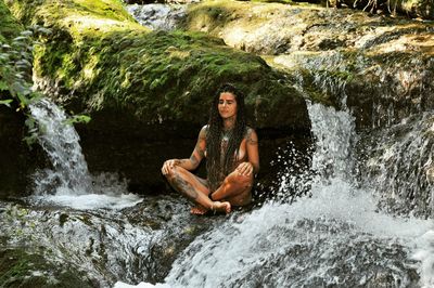 Portrait of young man splashing water in rock