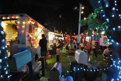 Crowd on illuminated market at night