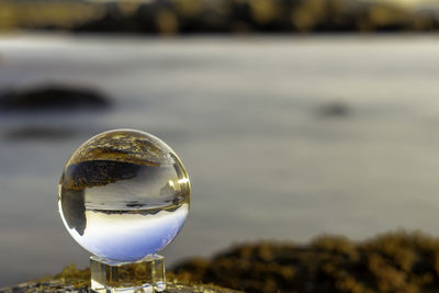 Close-up of crystal ball with reflection in water