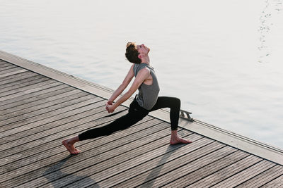 Woman relaxing on pier over lake