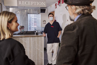 Patients and doctor at reception desk
